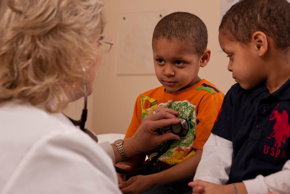 Two young boys being examined by a clinician